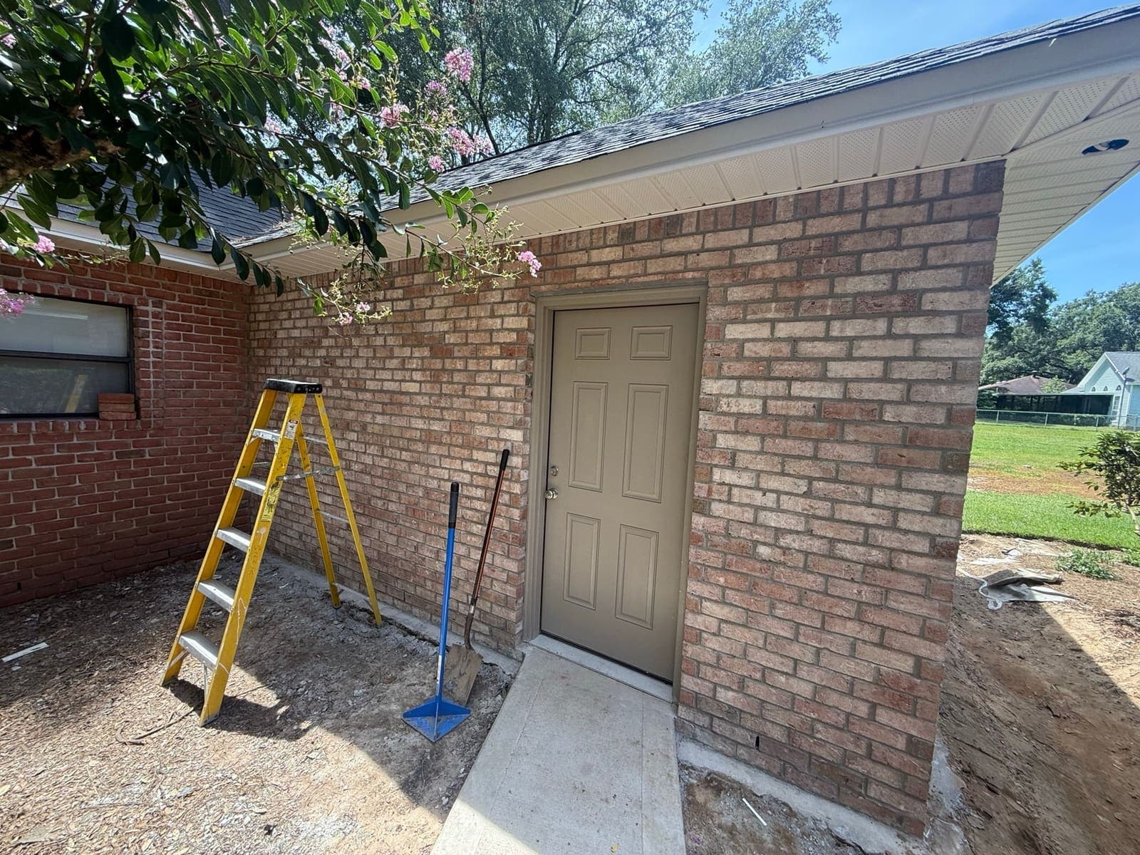 New brickwork up alongside the entry door with the ground still open around the footing