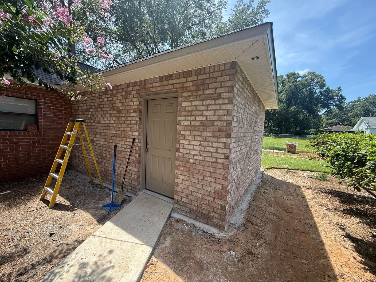 The completed brick walls and roof of the addition before final grading