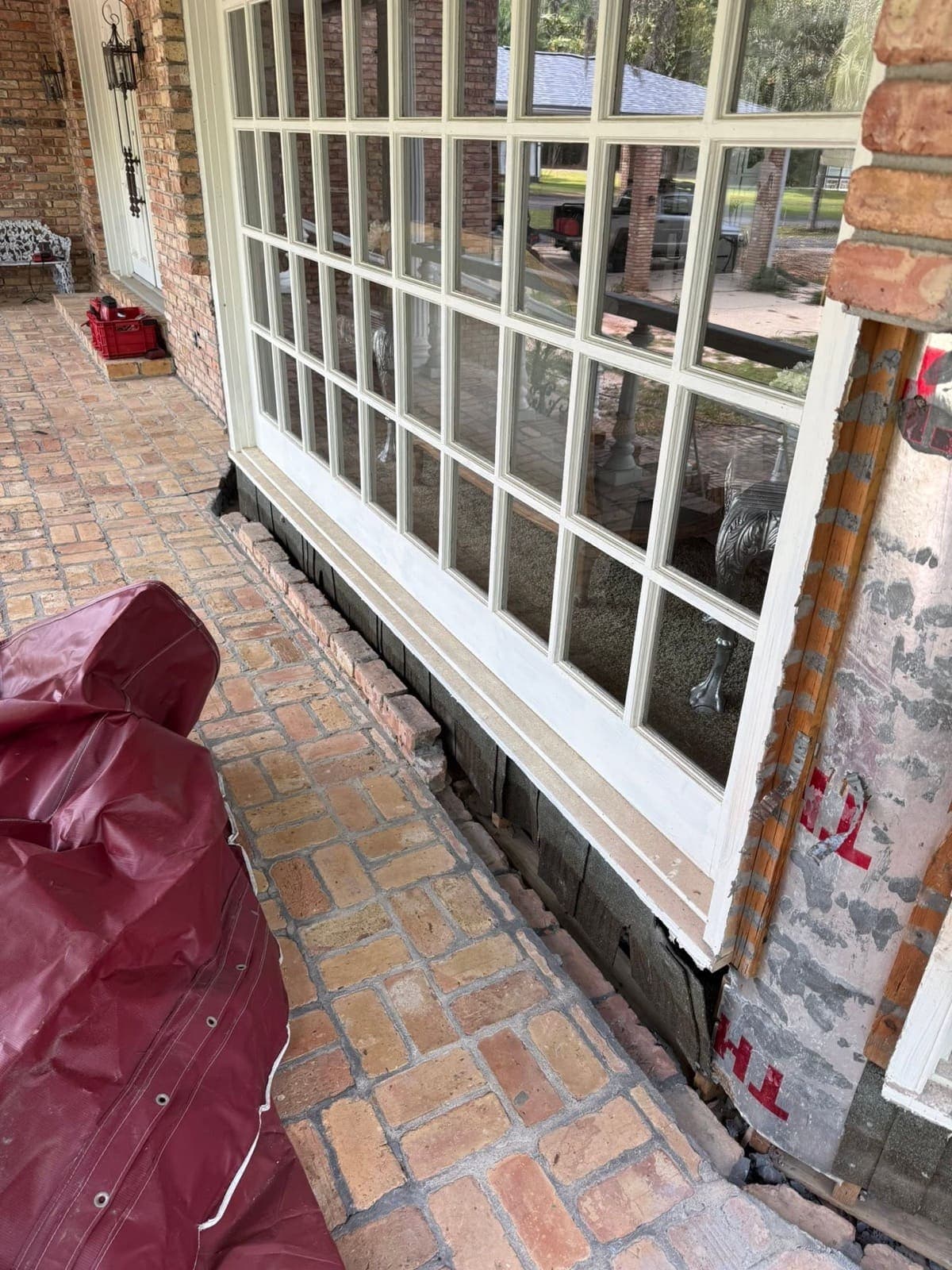 Window opening supported with the failed brick removed and the wall exposed mid-repair