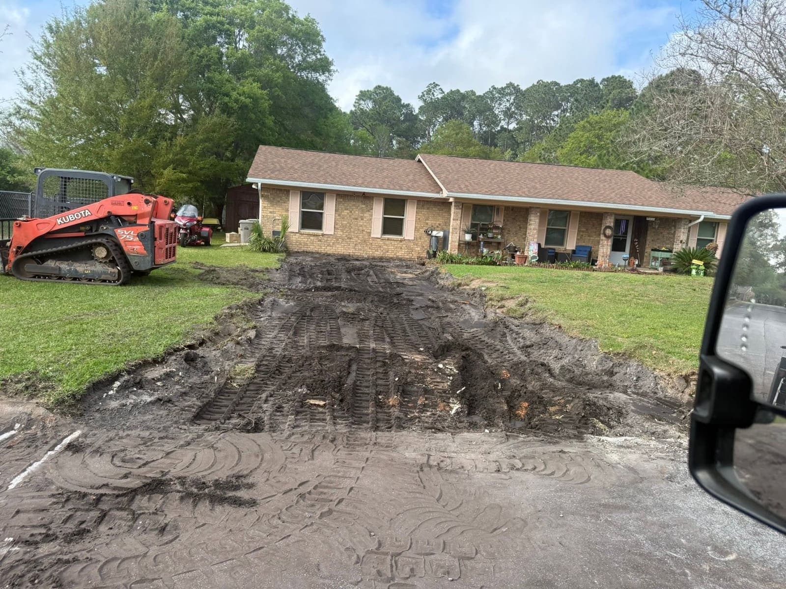 Driveway excavated to bare dirt and regraded before the base was compacted