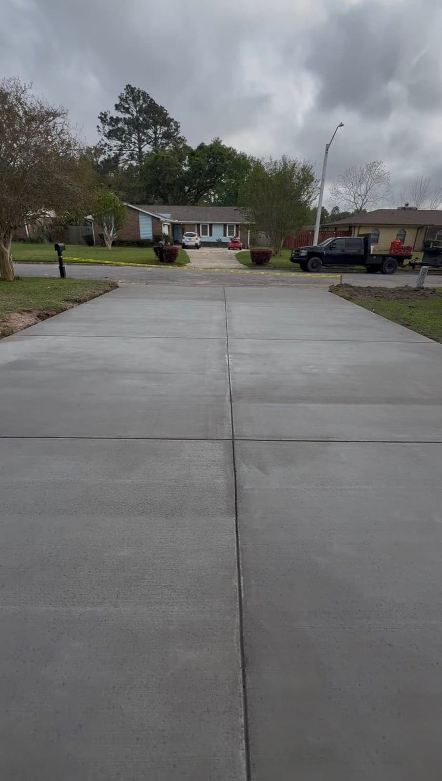 Freshly poured concrete driveway running from the street up to a home in Milton, Florida