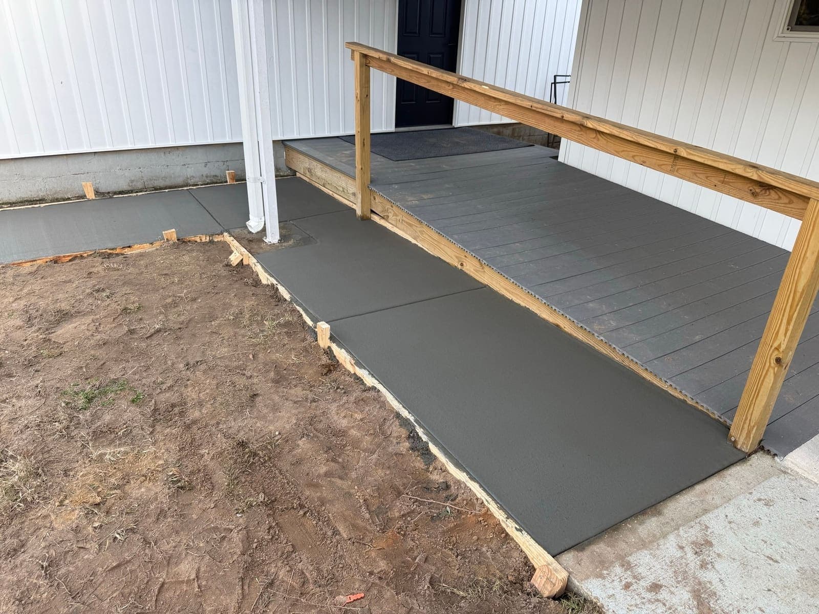 The finished ramped approach and handrail at the main entry door