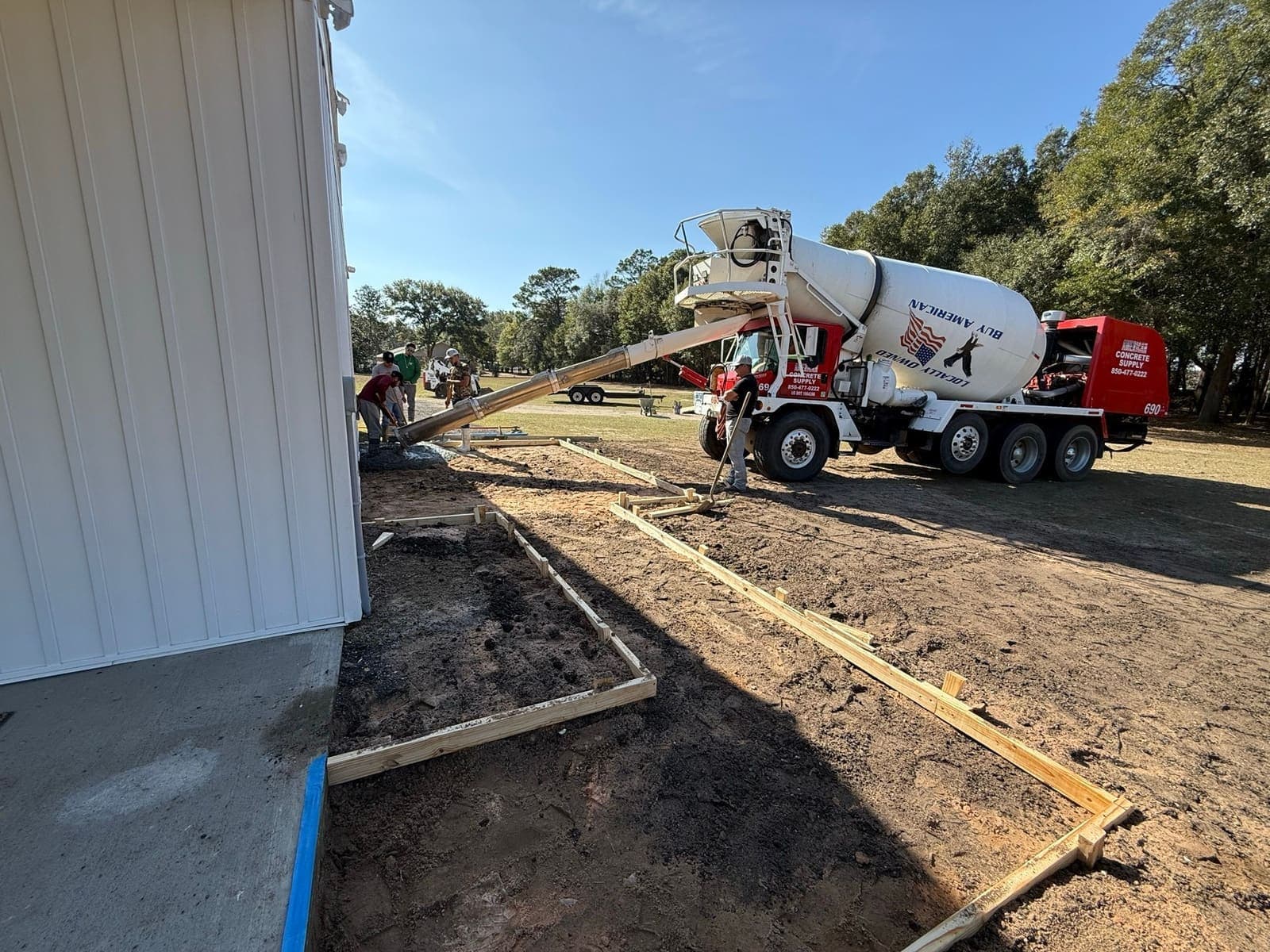 Concrete being placed from the truck chute into the formed walkway